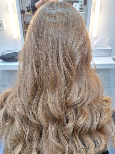 Melena larga con coloración vegetal en rubio dorado, realizada con barros orgánicos.