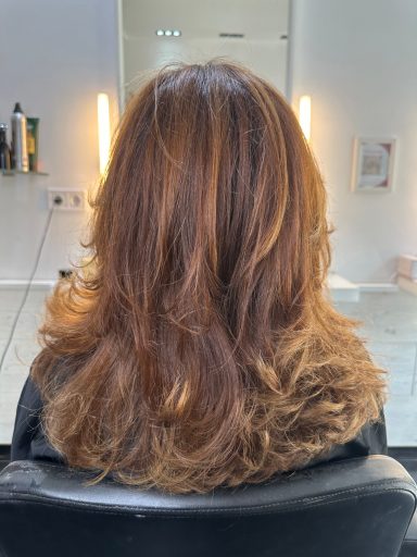 Melena larga en cobrizo dorado con mechas, coloreada con óleos botánicos para un acabado luminoso, suave y sin químicos.







