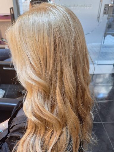 Melena larga rubia tratada con coloración a base de óleos naturales, brillo y tono suave sin químicos.